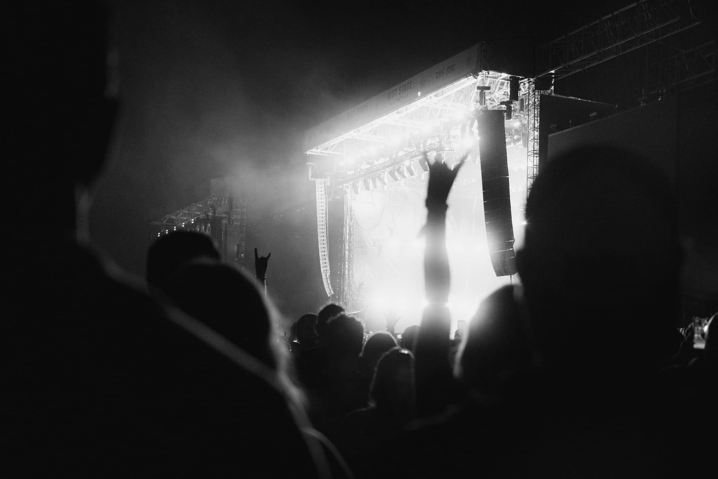 Crowd facing a brightly lit live music stage