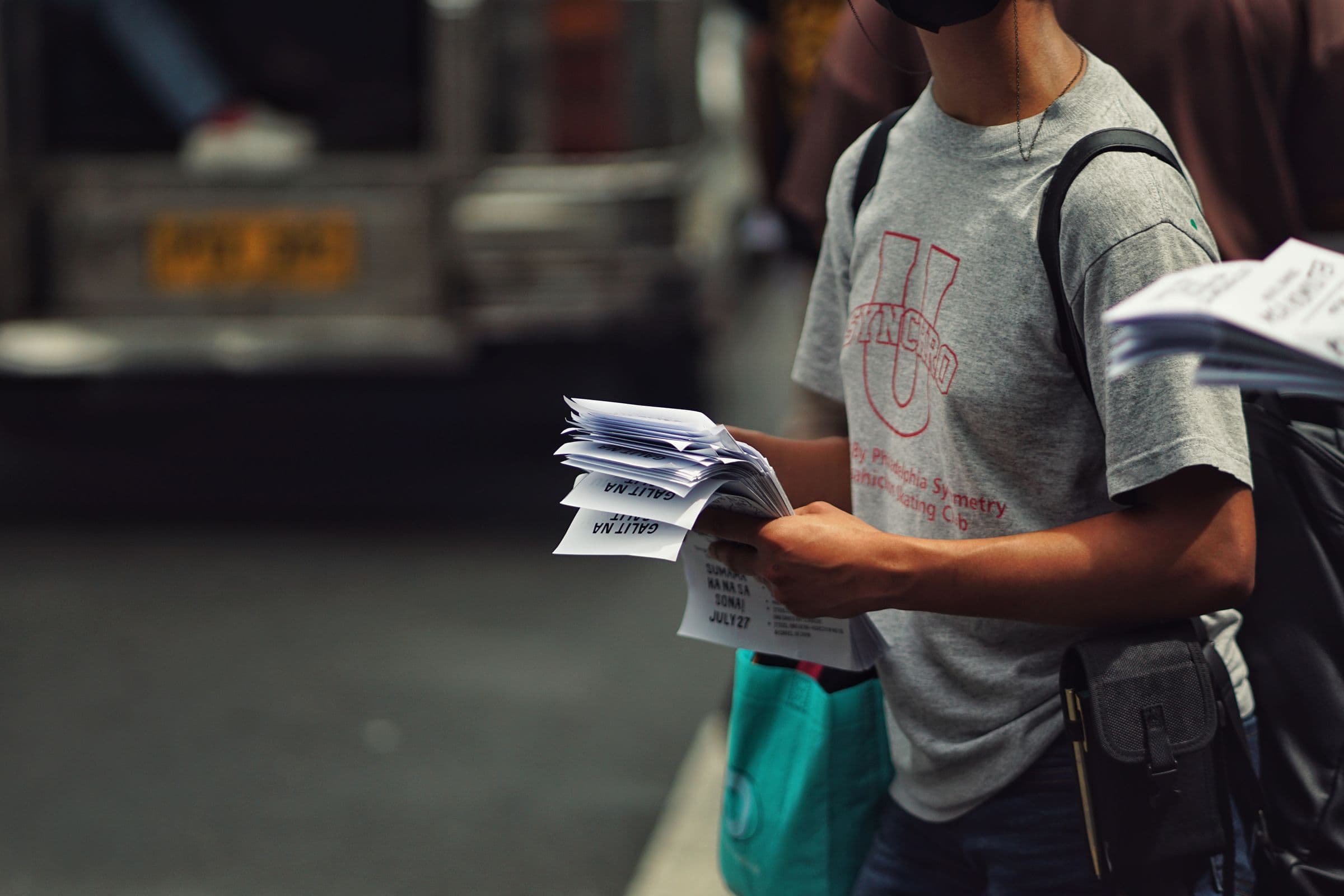 Street promoter holding a stack of flyers