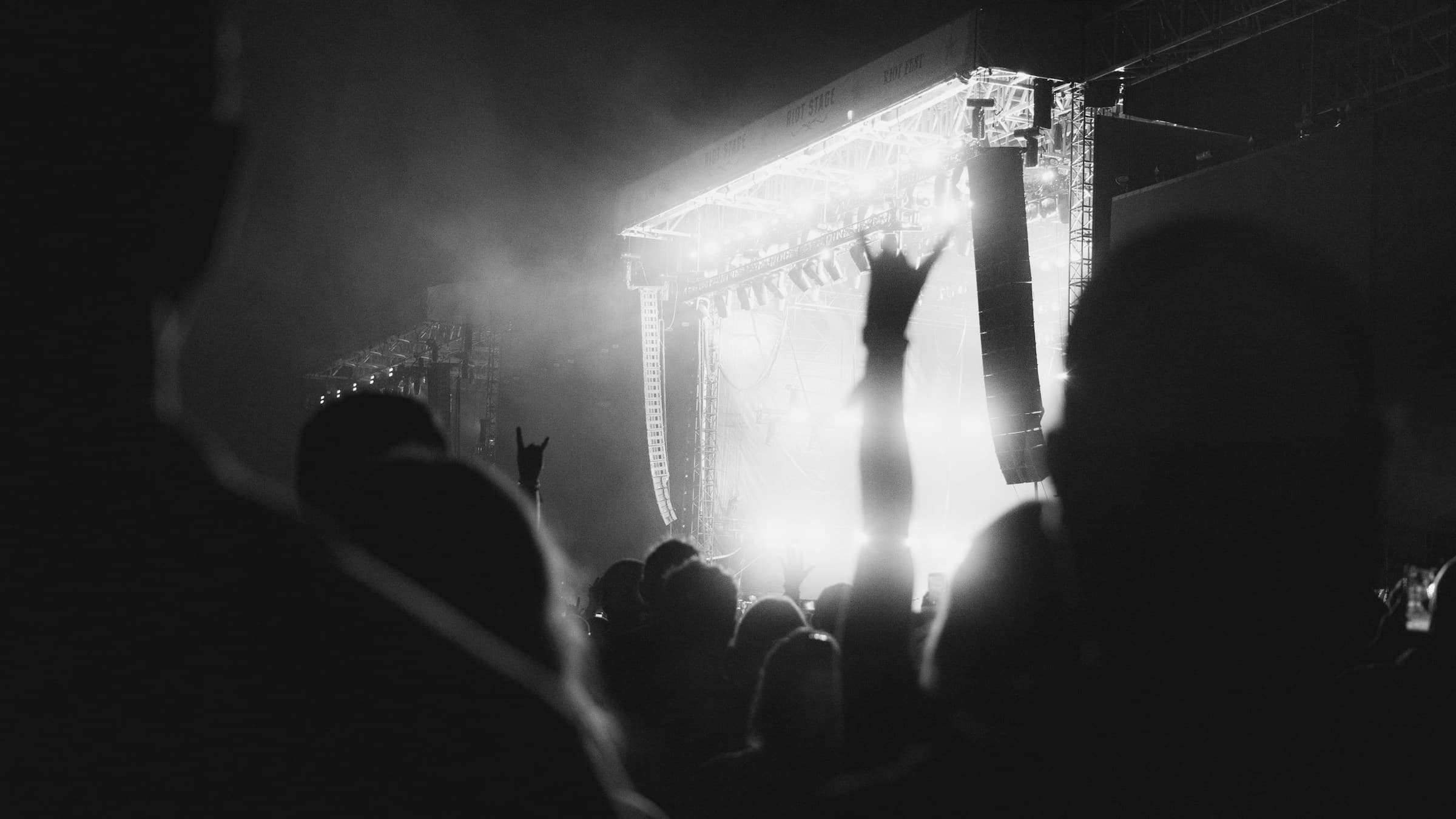 A crowd facing a brightly lit stage at a live show.